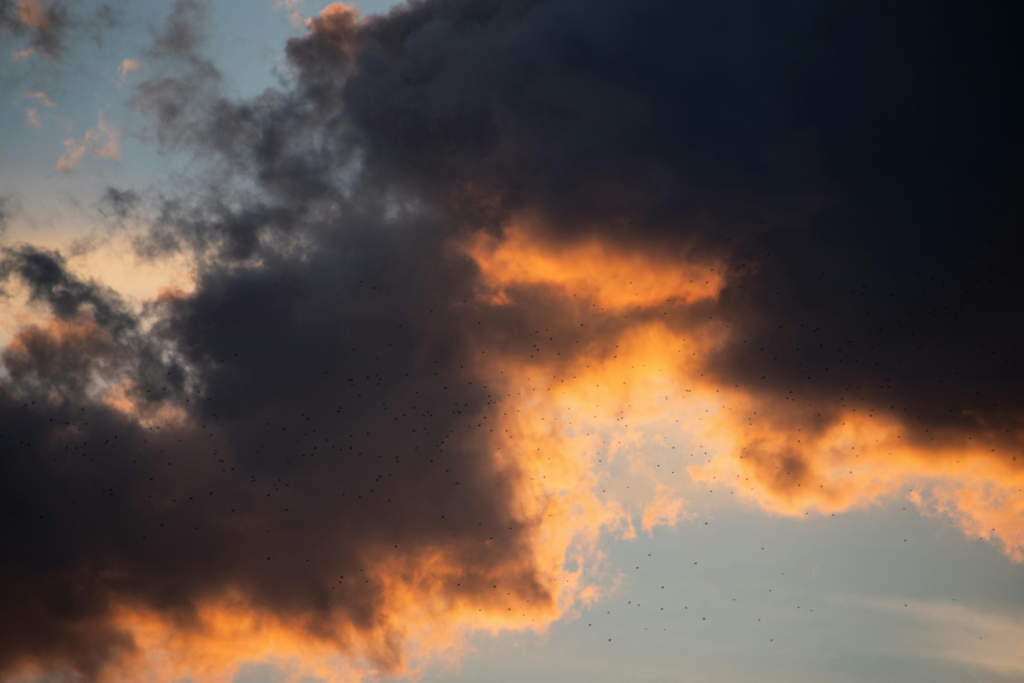 Dark clouds part at sunset, with light breaking through