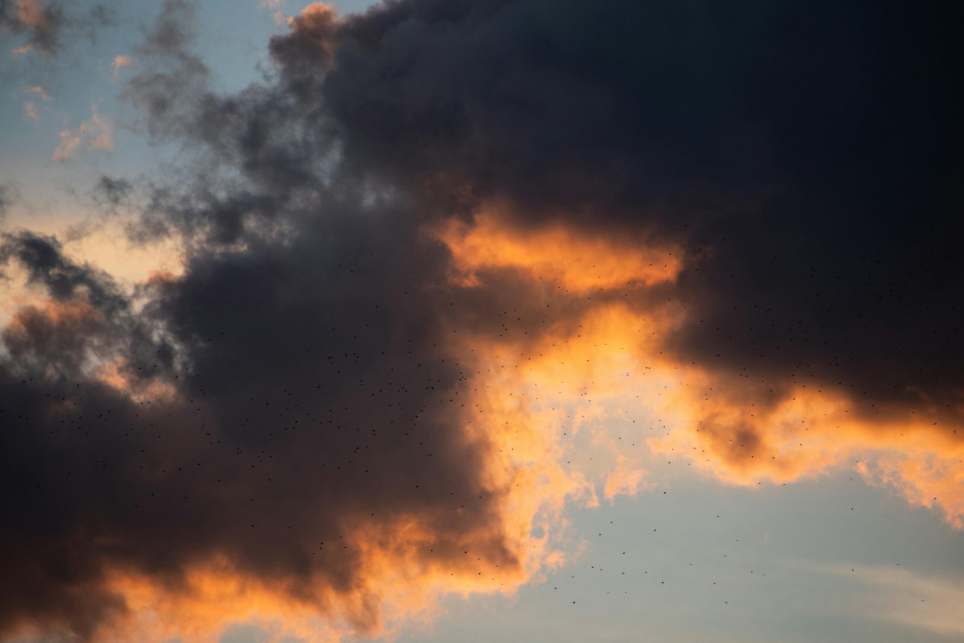 Dark clouds part at sunset, with light breaking through