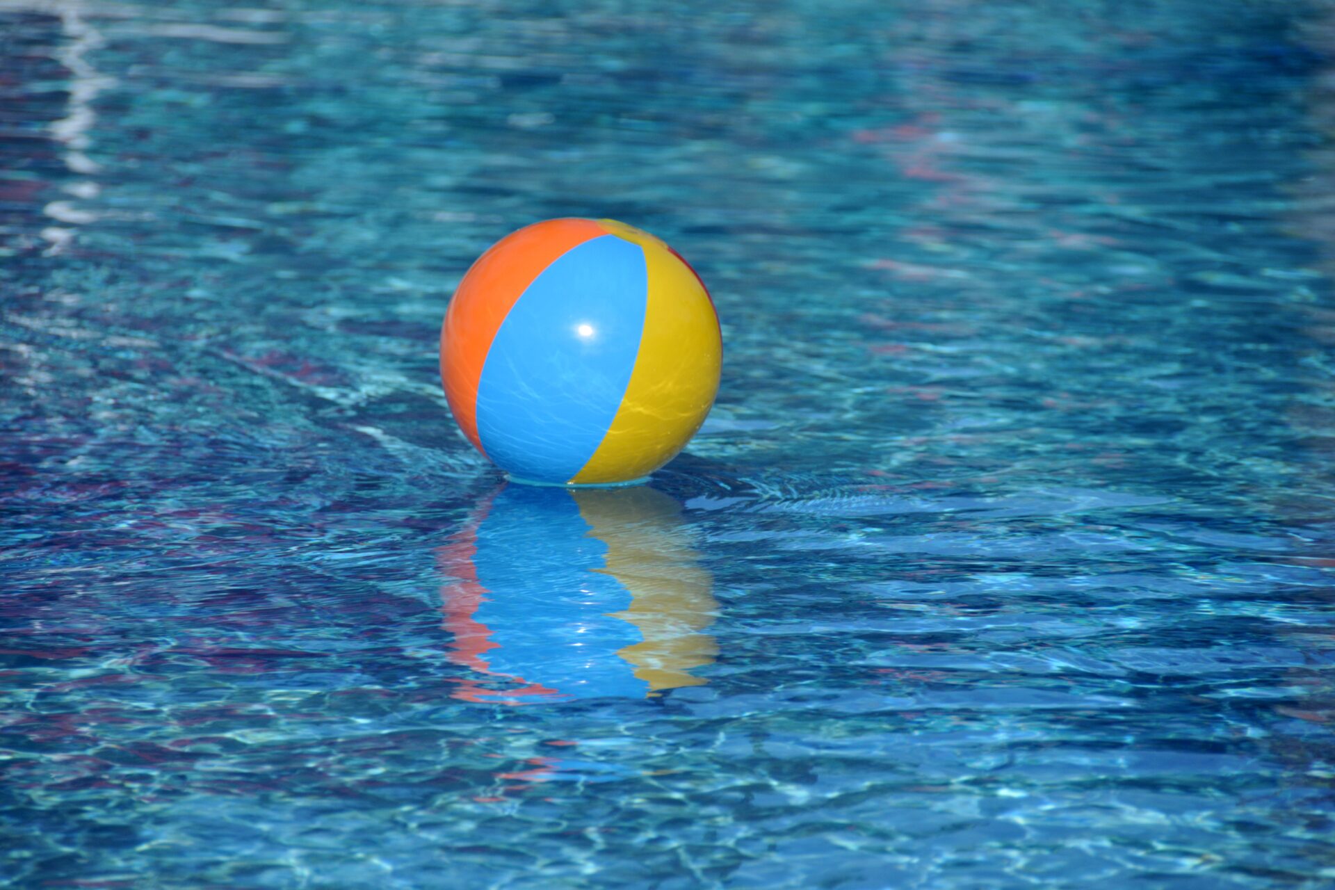 Beach ball floating on water, representing resilience and the ability to stay afloat through changing market conditions.